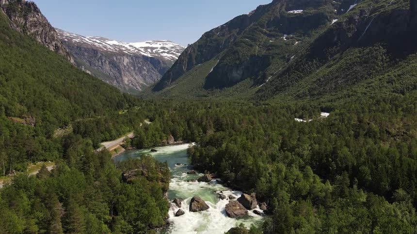 Panorama of a flowing river amid mountains and forests