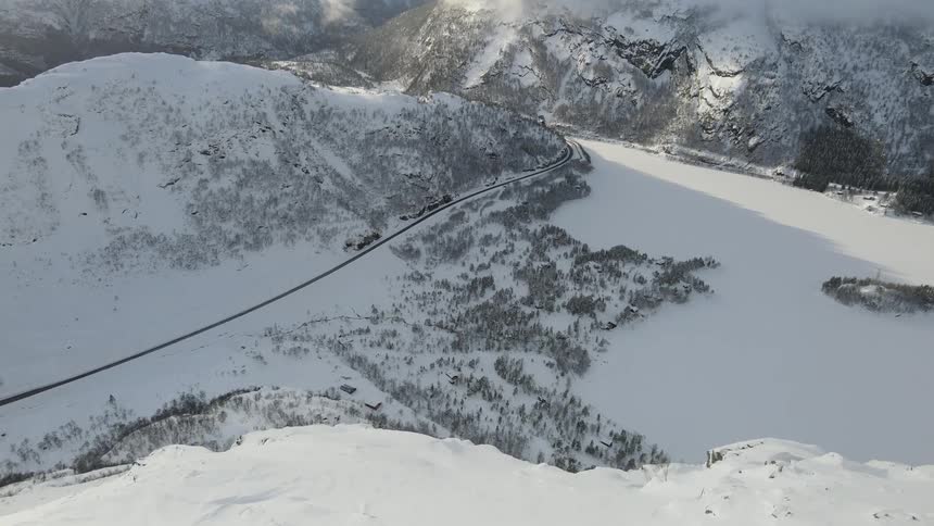 Aerial of an arctic mountain range with a deserted road on a cold day