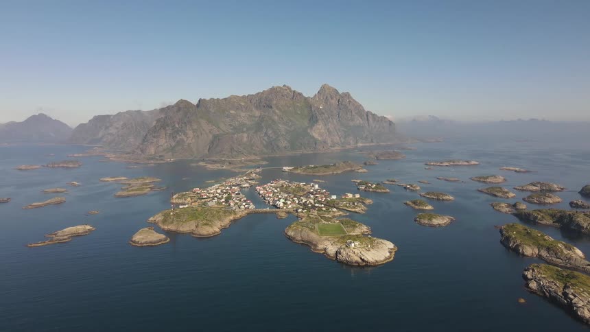 An aerial view of several islands in an ocean and a huge mountain