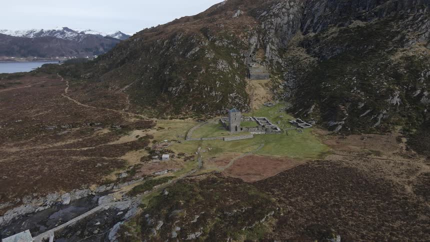 Aerial view of an ancient castle in the mountains next to a lake