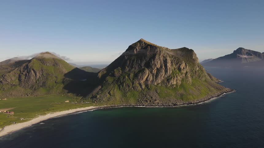 Aerial of an island with mountains with blue ocean during the day