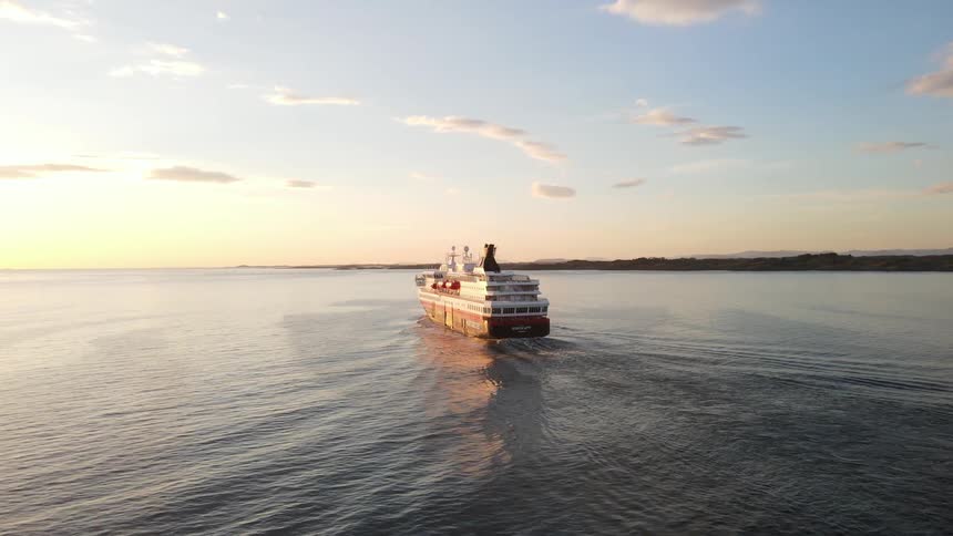The sun shines upon a cruise ship as it sails across the water