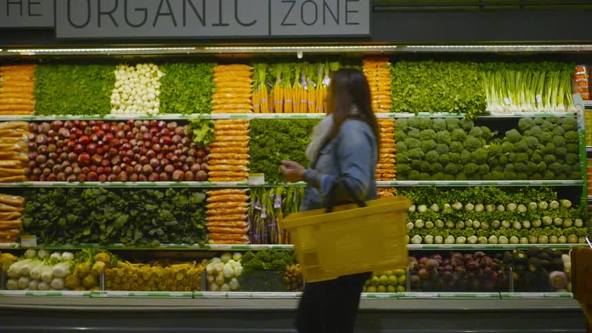 A person walks by a vegetable display
