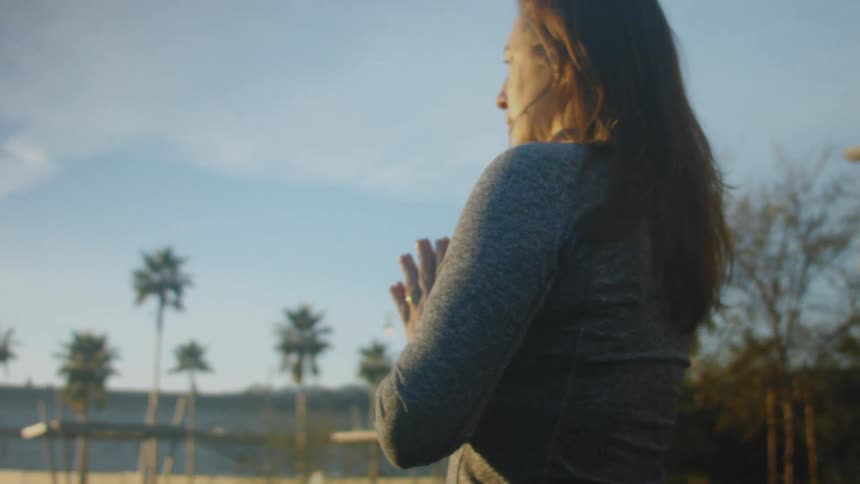 A woman is looking at the sun in the horizon