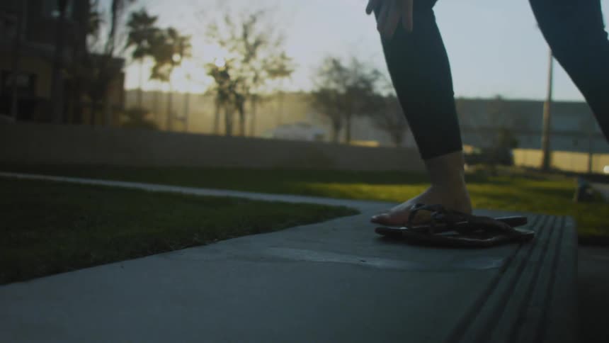 A person is walking barefoot on the grass