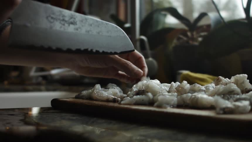 A person is cutting up seafood on a board