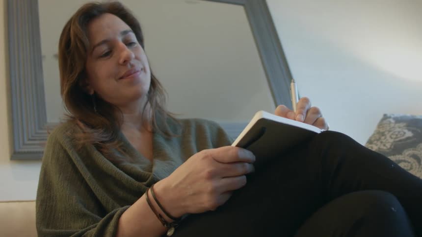 A woman writes in a notebook