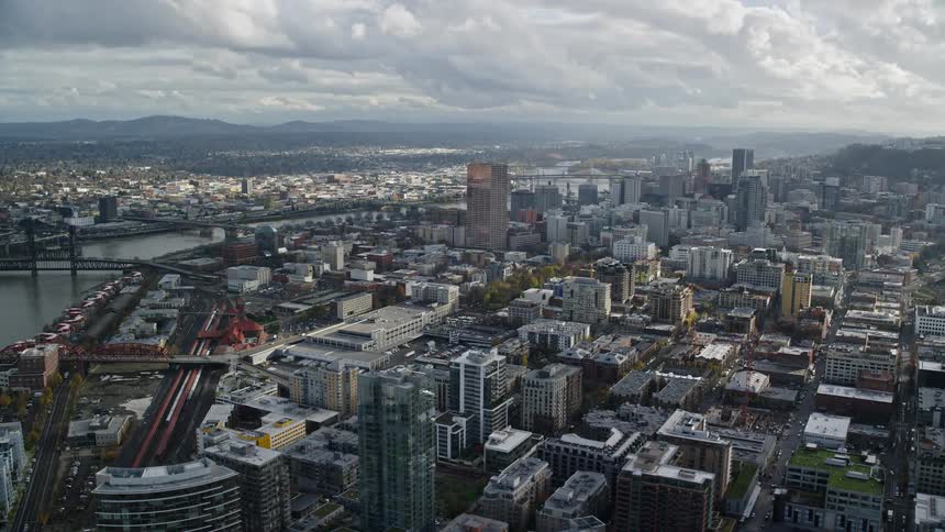 Aerial panorama of a metropolis by a lake on a cloudy sky day