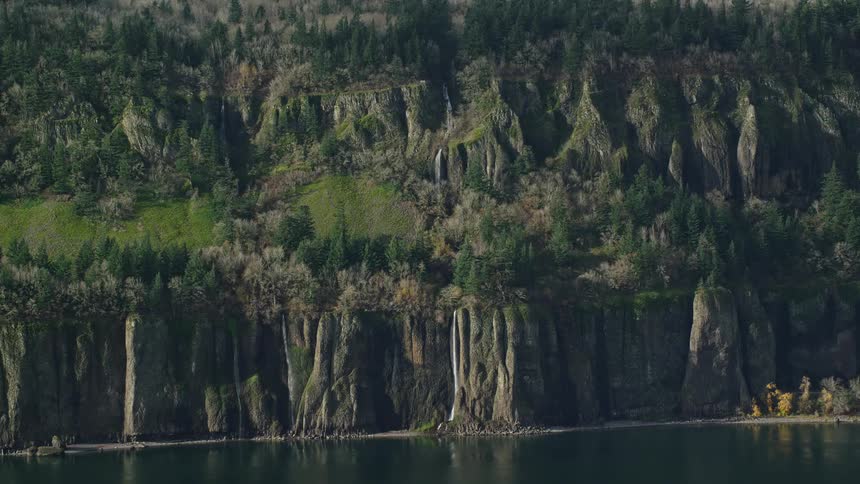 Aerial panorama of mountains with waterfalls facing a lake