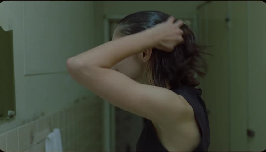 Portrait of a woman in the bathroom rinsing her hair and asking how it looks