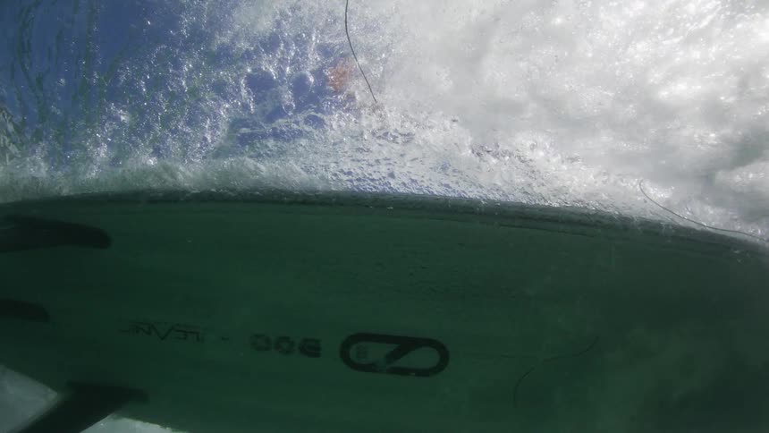 View from inside the sea of a surfboard gliding by