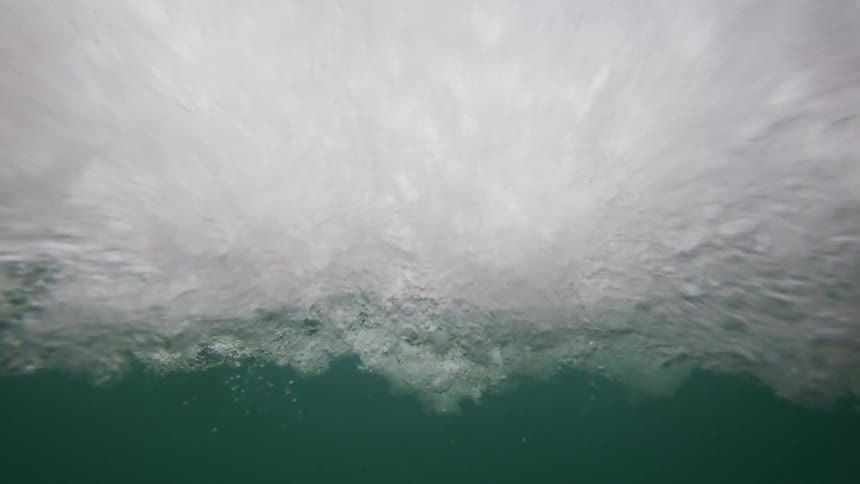 A waves splashes and curls as it rolls overhead