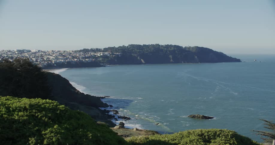 Panorama of a beach with an urban city on the horizon on a clear sky day