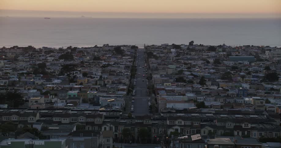 Panorama of an urban city by the sea with a reddish sky as the sun rises on the horizon