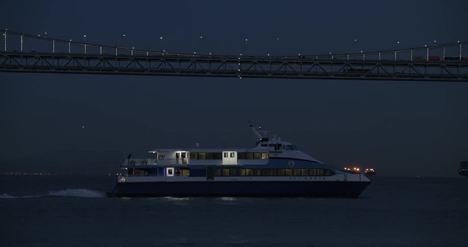 A ferry is traveling past the bridge