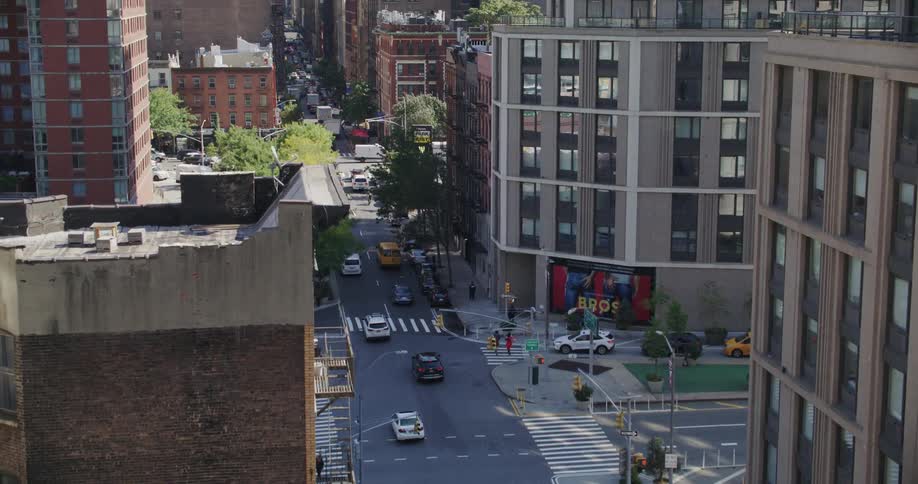 Cars driving on a busy narrow street in new york city on a sunny day
