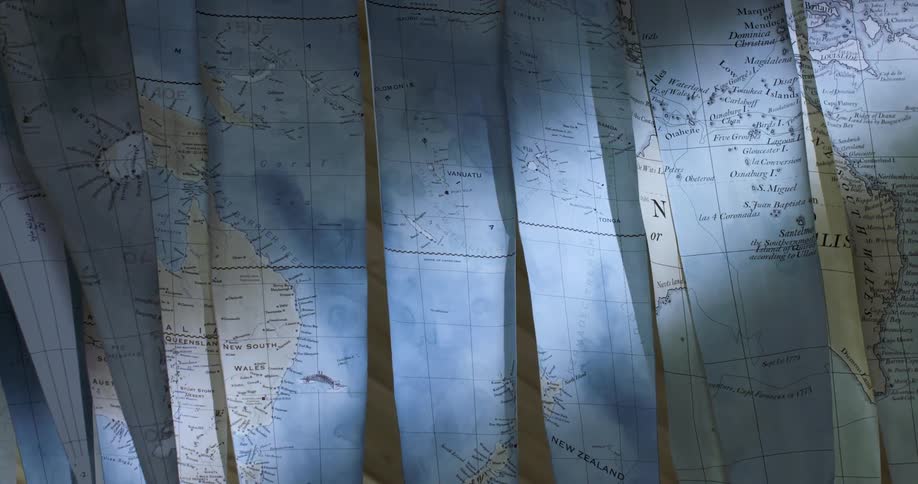 Strips of maps for a globe hanging to dry