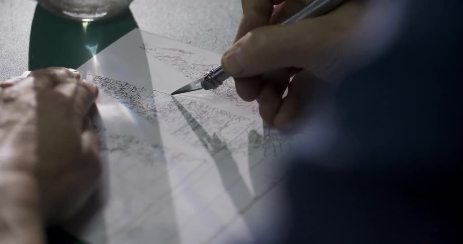 Closeup of a mans hands cutting a piece of paper
