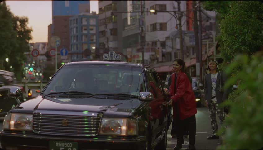 Friends wave to another friend as she gets in the cab