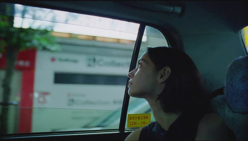 A woman in a car is looking at billboards on city buildings