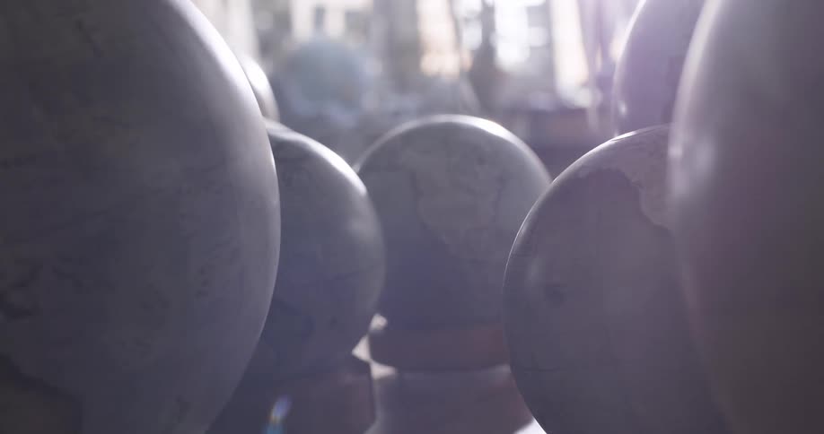 Globes on a table with a solar reflection