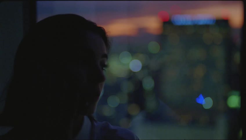 Woman talking on smartphone is silhouetted against the city skyline