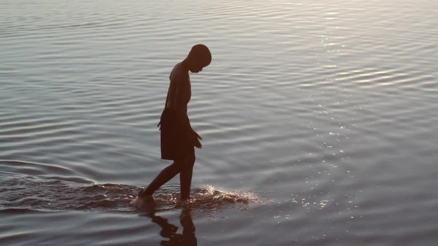 A boy walks in the water