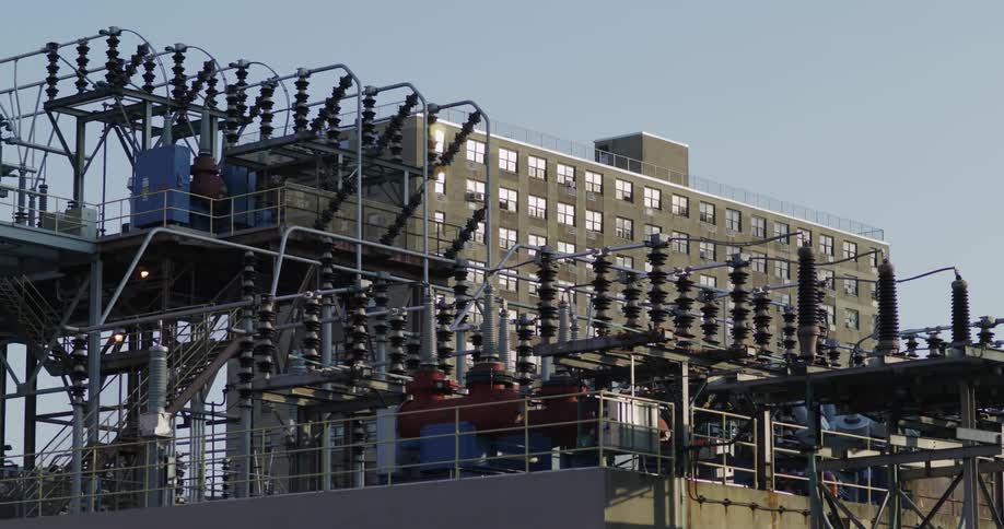 Bus passing by and opening a view to a residential apartment in front of a power station in daylight