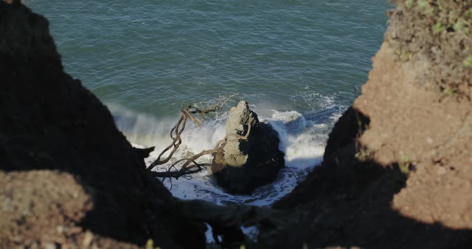 Sea coast with waves breaking on the rock during the day