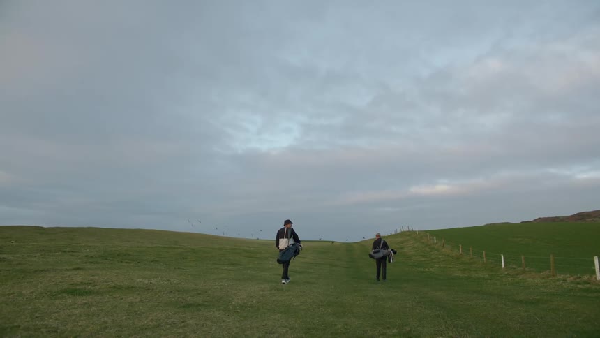 Two people walk down the landscape