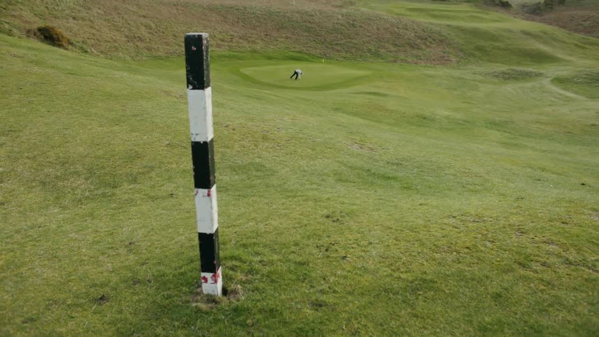 A person on a golf course during a cloudy day