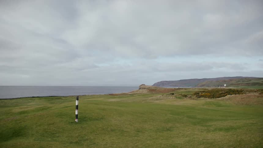 Landscape of a field overlooking the sea on a cloudy day