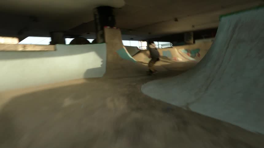A man is riding his skateboard on all the ramps in the park