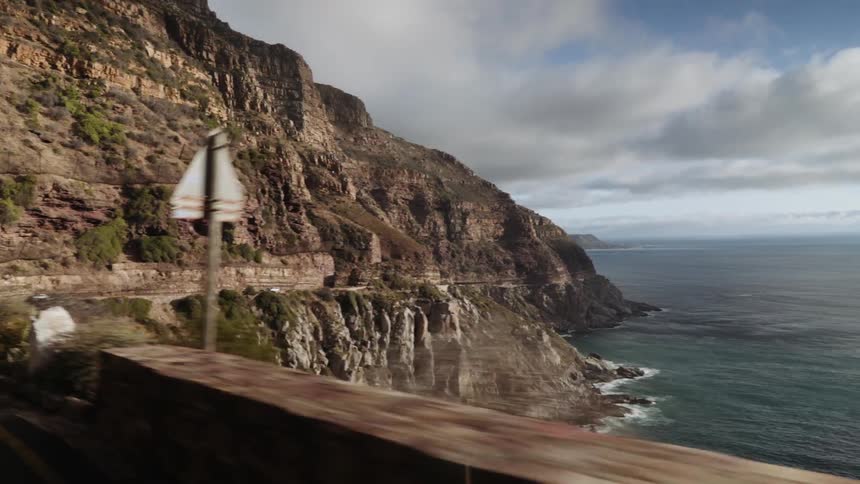 Vehicles travel along a seaside cliff