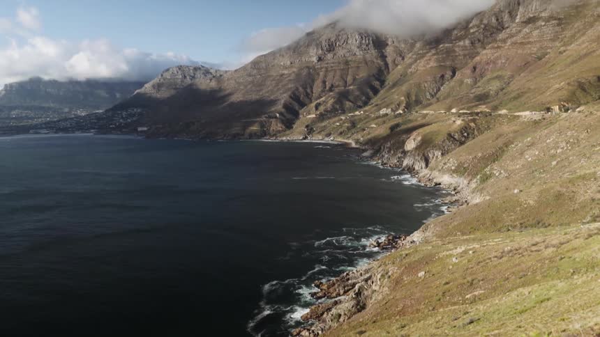 The water is crashing against the side of this mountain range