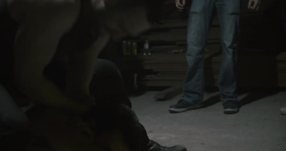 Two men are engaged in a fist fight as a crowd of people watch