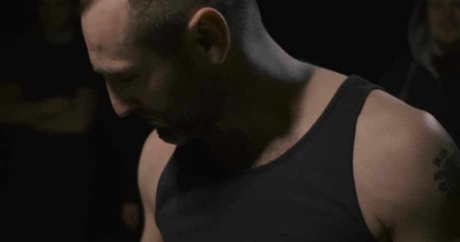 Man wipes blood from his mouth and then looks up and smiles