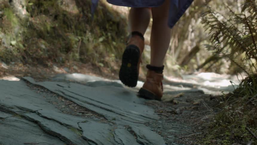 A woman walks down a rocky path