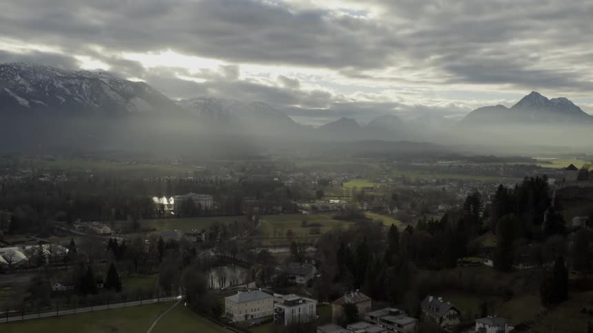 Sun peaks in through the clouds above down on the town