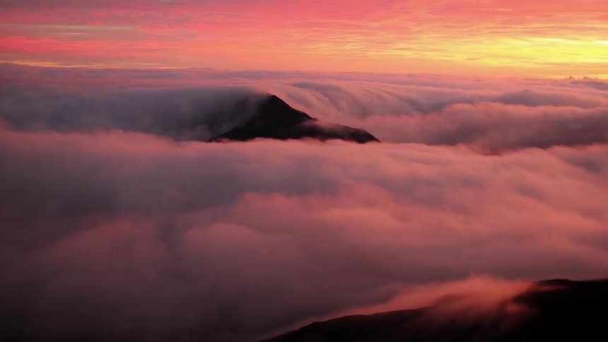 The sun sets over clouds