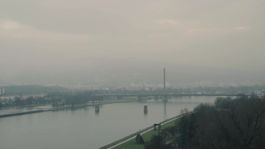Traffic crosses a bridge that spans a river near a city