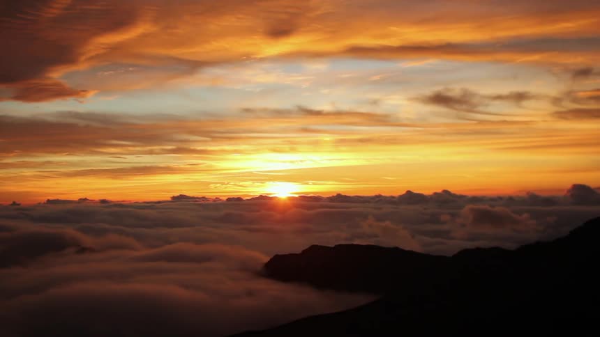 The sun is setting behind the clouds