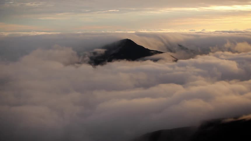 Clouds cover this mountain at sunset