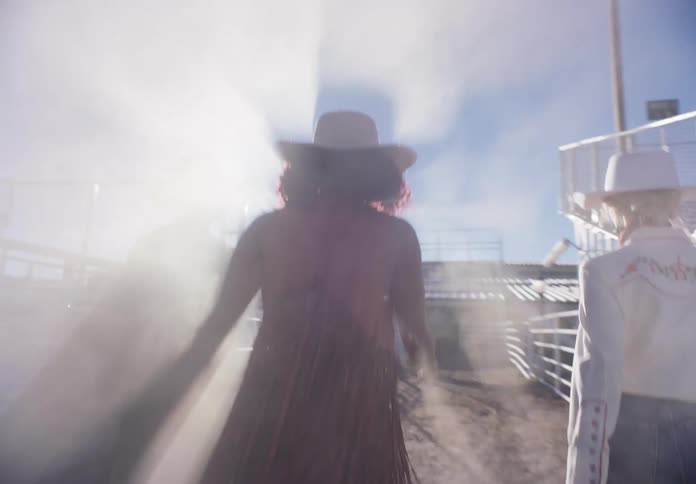 Women walking through the rodeo arena during cloudy morning