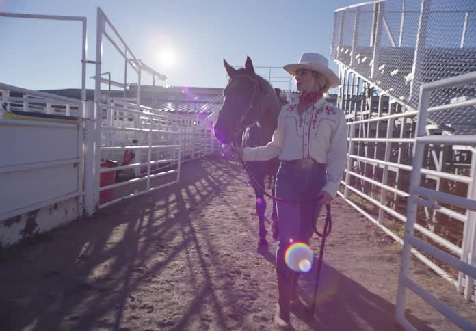 Cowgirl leads a horse to the rodeo