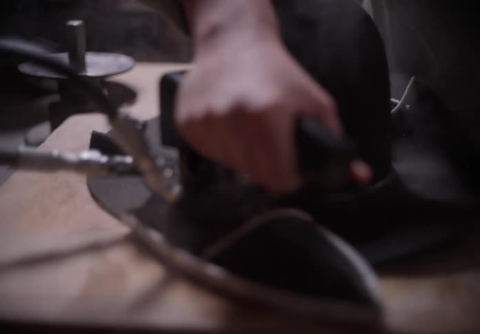 A worker is ironing the brim of the hat