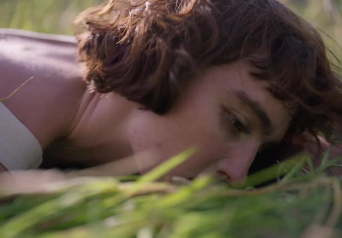 A woman is rolling around in the grass
