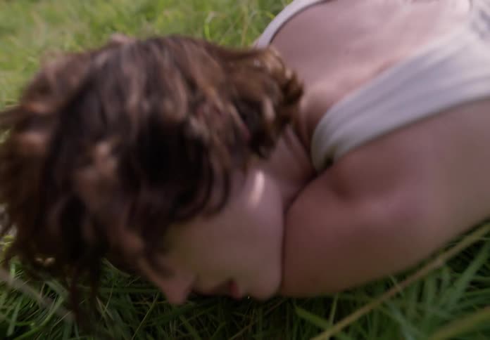 The woman is rolling around in the grass