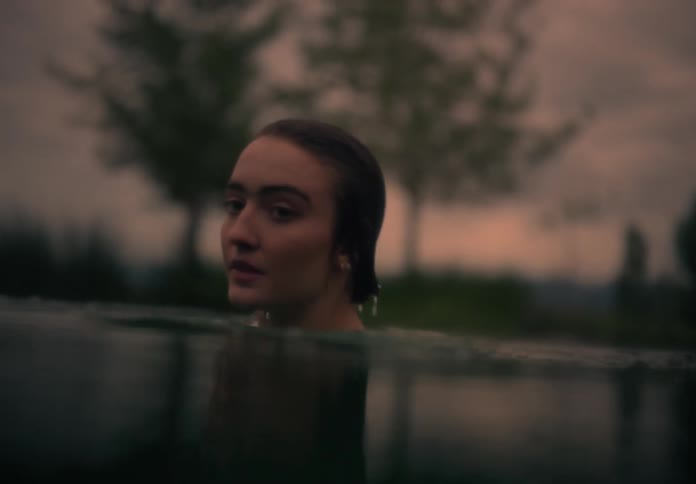 A girl swimming in a lake during sunset