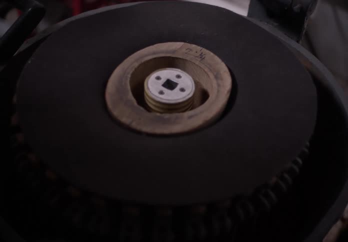 A persons hand setting up a machine in a factory